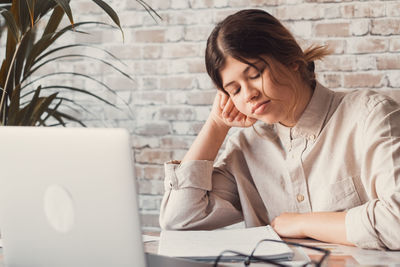 Young woman using laptop while sitting at office