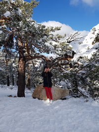 Full length of woman standing on snow covered mountain