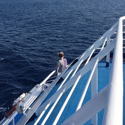 High angle view of woman on cruise ship sailing in sea during sunny day