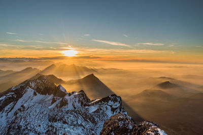 Scenic view of snowcapped mountains against sky during sunset