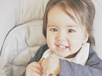 Portrait of cute baby girl on bed at home