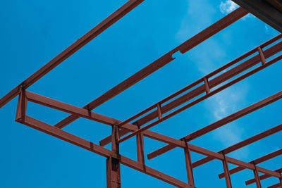 Low angle view of metallic structure against blue sky