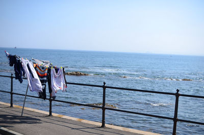 Deck chairs on beach against clear sky