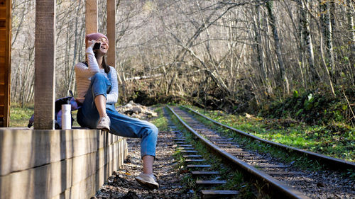 Side view of young woman on railroad track