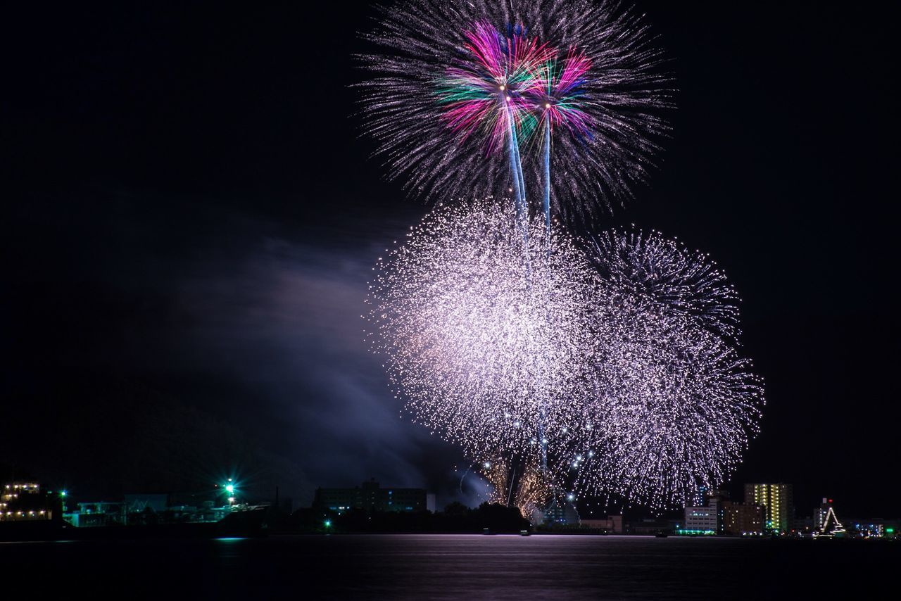 night, illuminated, firework display, celebration, exploding, firework - man made object, long exposure, sparks, motion, arts culture and entertainment, event, glowing, firework, blurred motion, entertainment, celebration event, sky, low angle view, smoke - physical structure, fire - natural phenomenon