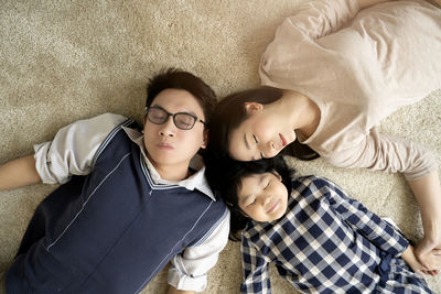 High angle view of parents with daughter lying on carpet