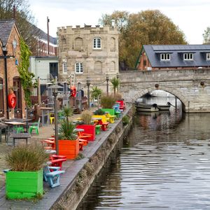 Bridge over canal by buildings in city