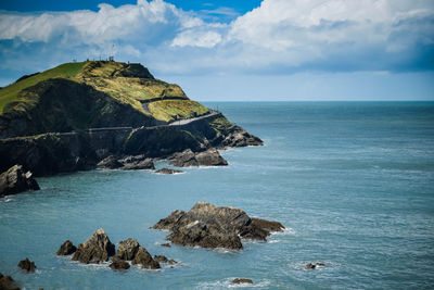 Scenic view of rocks in sea against sky