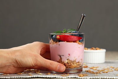 Cropped image of hand holding dessert on table