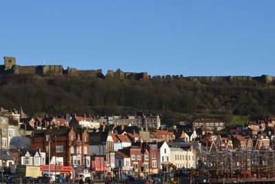 Houses in town against clear blue sky