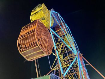 Low angle view of illuminated ferris wheel against sky at night