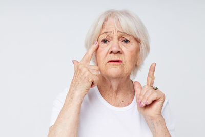 Portrait of young woman gesturing against white background