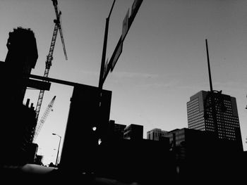 Low angle view of silhouette buildings against clear sky