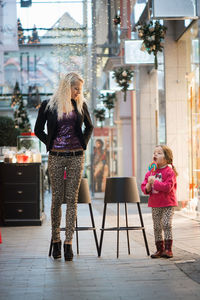 Full length of woman with daughter in shopping mall