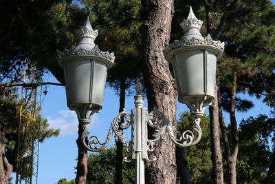 Low angle view of street light against trees