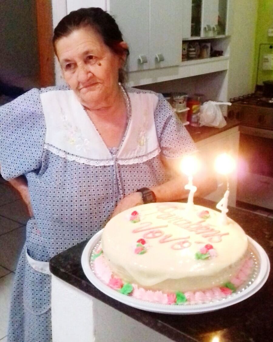 MID SECTION OF WOMAN WITH ICE CREAM IN KITCHEN