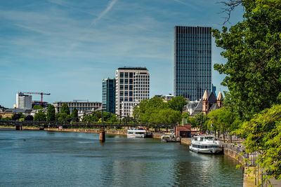 Buildings by river against sky