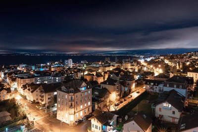 High angle view of illuminated cityscape against sky at dusk