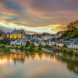 View of town by buildings against sky during sunset