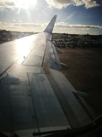 Airplane on airport runway against sky
