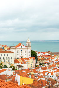 High angle view of townscape by sea against sky