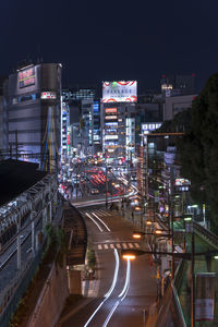 High angle view of illuminated road amidst buildings in city at night