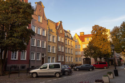 Cars on road by buildings against sky