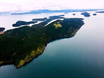 Scenic view of sea and mountains against sky