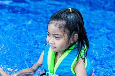 Portrait of cute girl swimming in pool