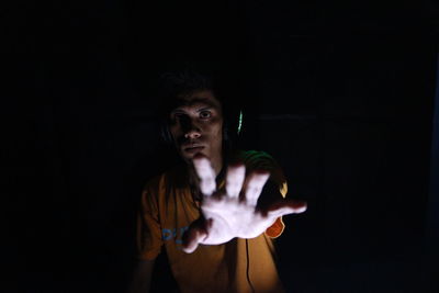 Portrait of young man against black background