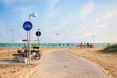 People riding bicycles on footpath at beach