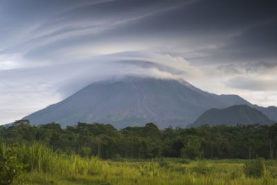 Scenic view of land and mountains against sky