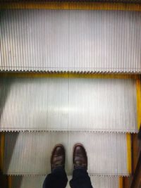 Low section of man standing on tiled floor