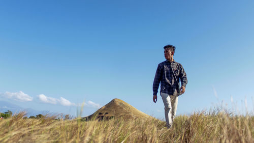 Full length of man standing on field against sky