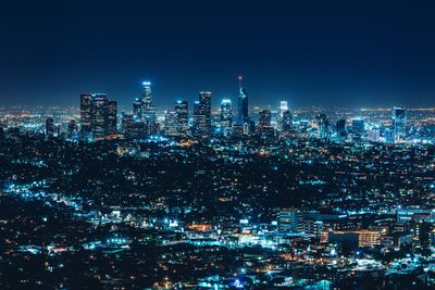 Illuminated cityscape against sky at night