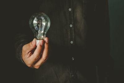 Close-up of hand holding light bulb