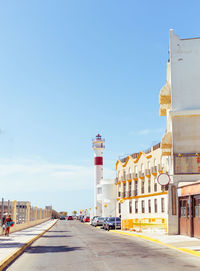 Road in city against clear blue sky