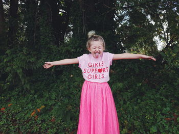 Portrait of happy girl standing on tree