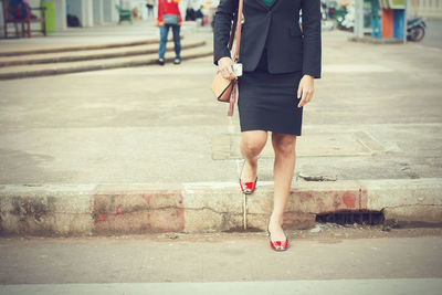 Low section of woman walking on footpath