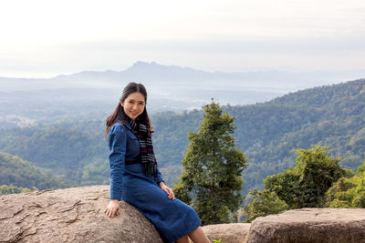 Portrait of smiling woman against mountains