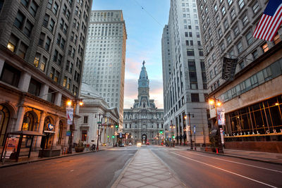 View of city street and buildings at dusk