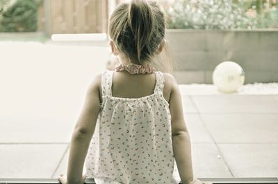 Rear view of woman standing against wall