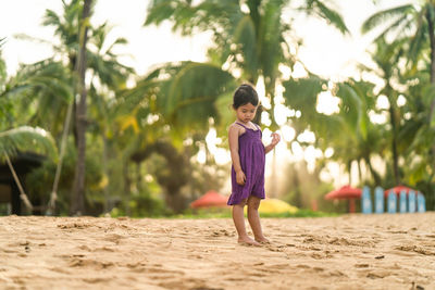 Portrait of cute girl on sand at beach