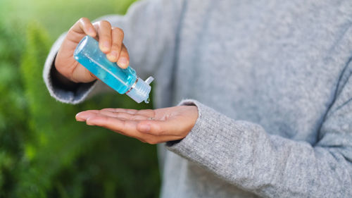 Close-up of woman hand holding bottle