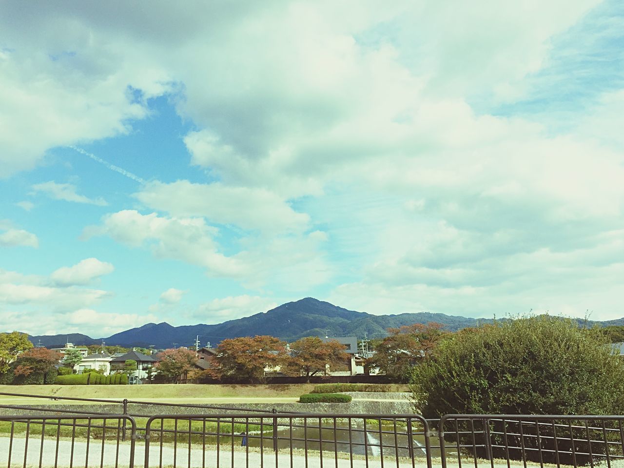 sky, mountain, cloud - sky, built structure, railing, architecture, tree, mountain range, cloud, cloudy, building exterior, nature, scenics, beauty in nature, blue, tranquility, tranquil scene, landscape, day, fence