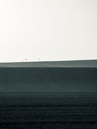 Scenic view of agricultural landscape against clear sky