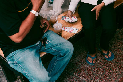 Low section of people playing cards