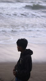 Man standing at beach against sky