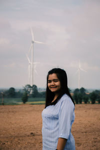 Portrait of smiling young woman standing on land