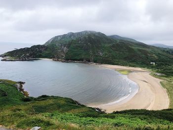 Scenic view of sea and mountains against sky